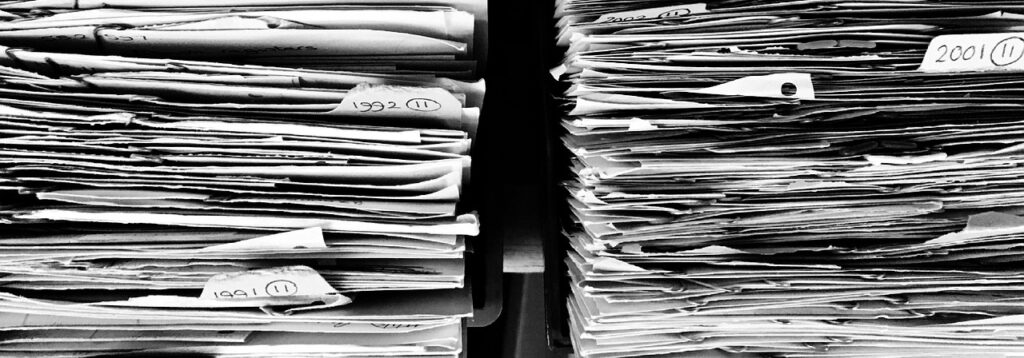 Stack of real estate paperwork showing need for transaction coordinator services in Minneapolis