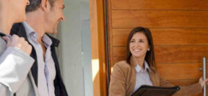 Real estate agent showing a home to buyers during a property tour — personalized home buying support services.